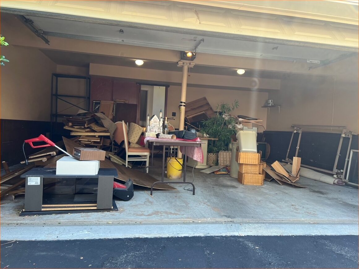A two car garage packed to the ceiling with boxes, tools and household items