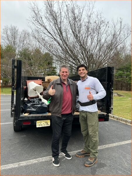 Romy shaking hands with a customer beside the loaded truck at the end of a job